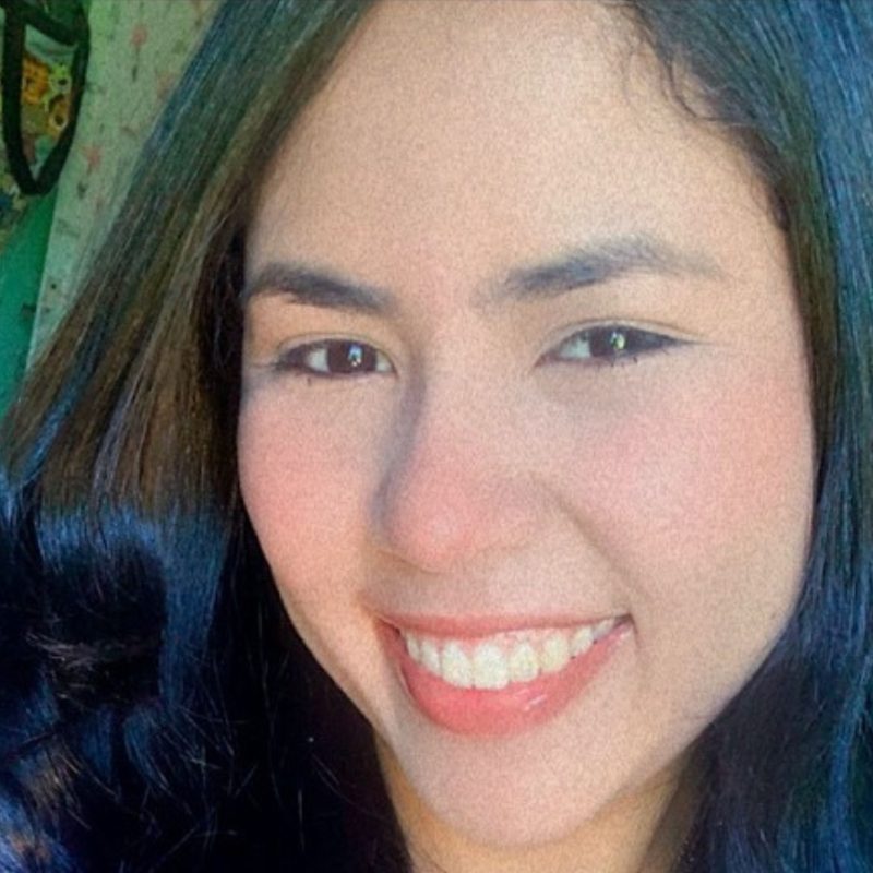 Foto da psicóloga Yully Yukie Paschoal Udono, especialista em Terapia Cognitivo-Comportamental (TCC) na clínica Presente Psicologia. Ela está sorrindo, veste um blazer terracota e transmite uma postura ética e acolhedora.