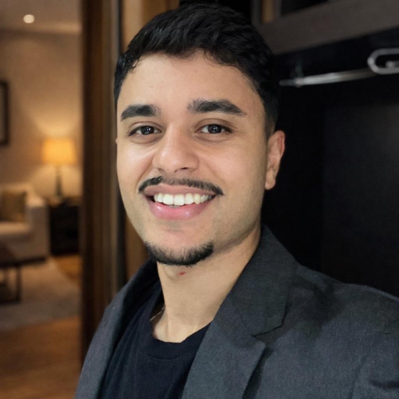 Foto do psicólogo Caique dos Santos Sampaio, especialista em Psicanálise na clínica Presente Psicologia. Ele sorri de forma acolhedora, tem barba, veste um blazer escuro e transmite profissionalismo e empatia.