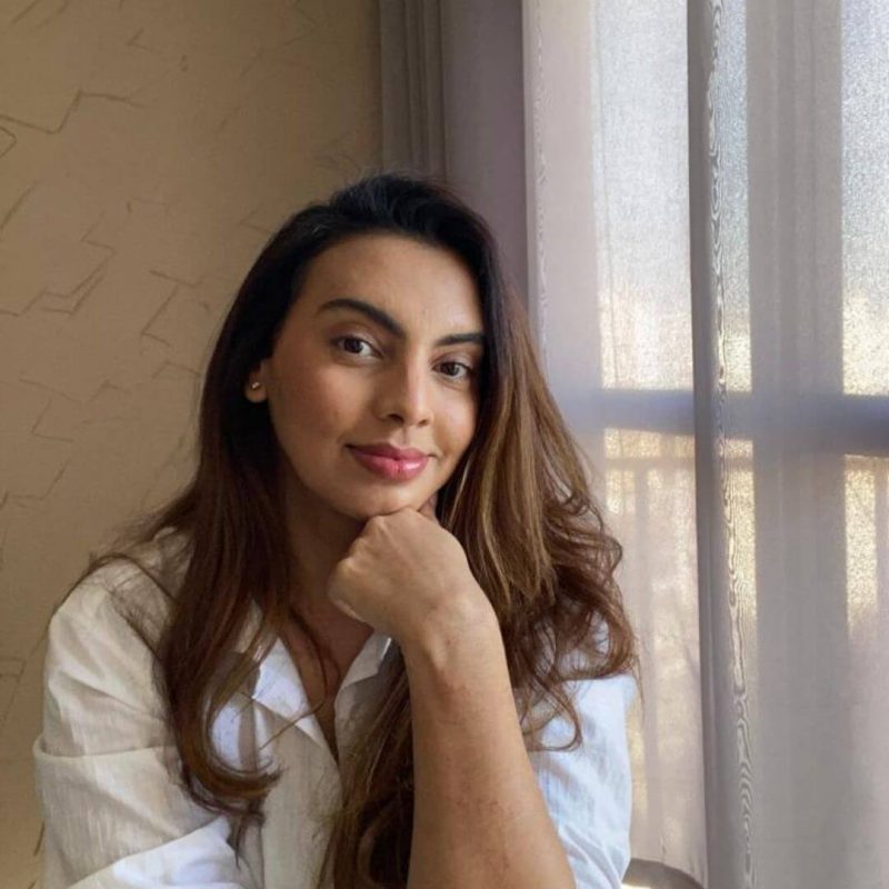 Foto da psicóloga Fernanda Laurindo Vitiello Azevedo, especialista em Terapia Cognitivo-Comportamental (TCC) na clínica Presente Psicologia. Ela sorri de forma acolhedora, tem longos cabelos castanhos e veste uma camisa branca.