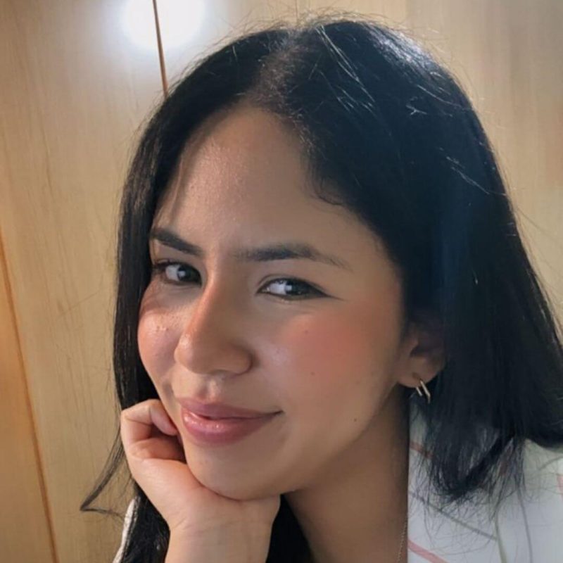 Foto de perfil da psicóloga Yully Yukie Paschoal Udono, especialista em Terapia Cognitivo-Comportamental (TCC) na clínica Presente Psicologia. Ela tem cabelos escuros, sorri levemente com a mão no queixo e transmite uma postura ética e acolhedora.